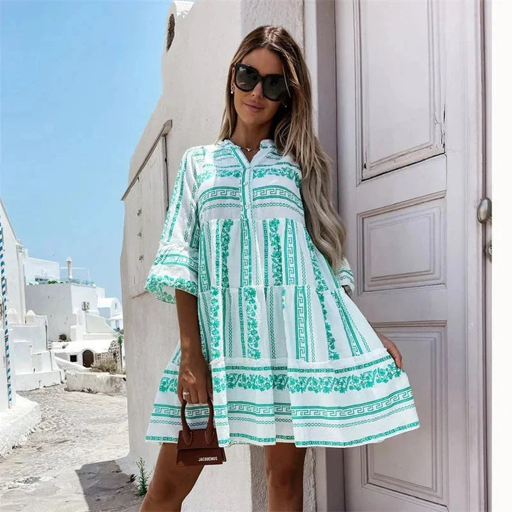 "Green women's v-neck mini dress with tiered skirt, made of airy fabric for effortless style."